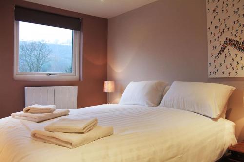 a bedroom with a large white bed with towels on it at Wharmton luxury apartment in Dobcross