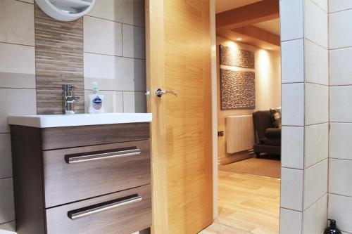 bagno con lavandino e specchio di Wharmton luxury apartment a Dobcross