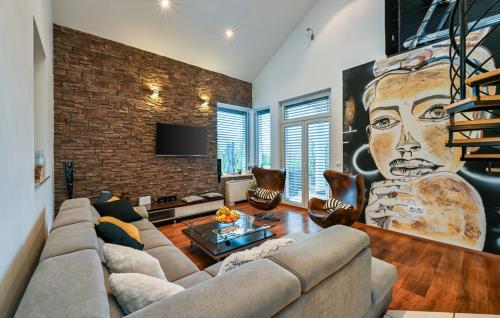 a living room with a couch and a brick wall at Casa M in Lopatinec
