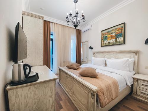 1 dormitorio con 1 cama grande y TV en Aspar Boutique Hotel en Ereván