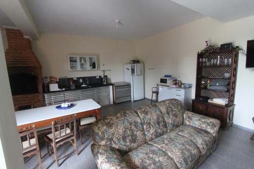 Una sala de estar con un sofá y una cocina. en Estação Brotense - Casa com piscina e fogueira exclusiva, en Brotas