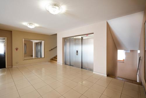 an empty hallway with doors and a tile floor at Apartmány Jako doma in Pilsen
