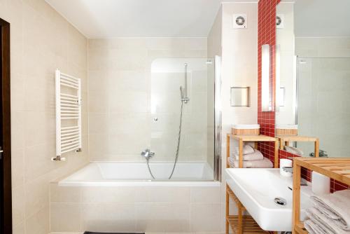 ein Badezimmer mit einer Badewanne und einem Waschbecken in der Unterkunft Apartmány Jako doma in Pilsen