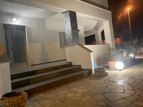 a house with stairs and a door with a light at Bed and breakfast KALE ' in Porto Cesareo