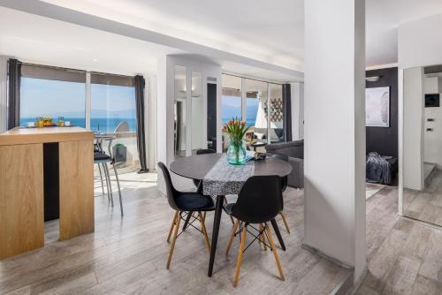 Lux Apartment SKY VIEW في رييكا: غرفة طعام وغرفة معيشة مع طاولة وكراسي