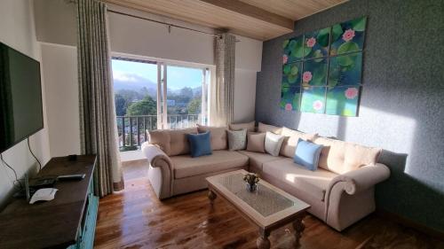 a living room with a couch and a table at Knightsbridge Grand Apartment in Nuwara Eliya