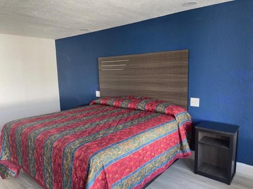 una camera con letto e parete blu di Motel Savannah a Savannah