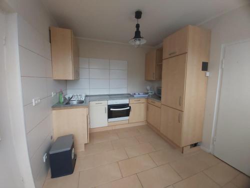 a small kitchen with wooden cabinets and a sink at Am Bahnhof Ketzin in Ketzin