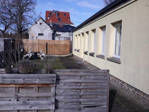 a house with a wooden fence next to a building at Am Bahnhof Ketzin in Ketzin