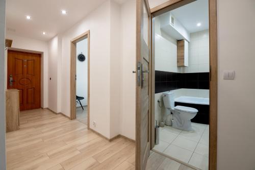 a bathroom with a toilet and a sink and a door at THE SOUL of Nowa Huta - free garage in Kraków