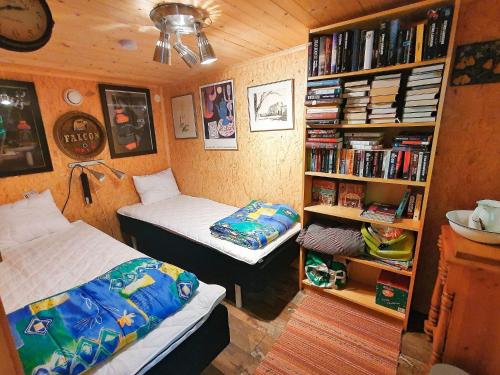 een slaapkamer met 2 bedden en een boekenplank bij Holiday home TJÖRNARP VII in Tjörnarp
