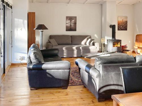 a living room with leather couches and a fireplace at Holiday home Åhus in Åhus