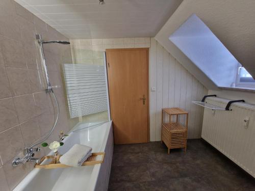 La salle de bains est pourvue d'une baignoire, d'une douche et d'un lavabo. dans l'établissement Ferienwohnung Haus Sonnenblick, à Burkhardtsdorf