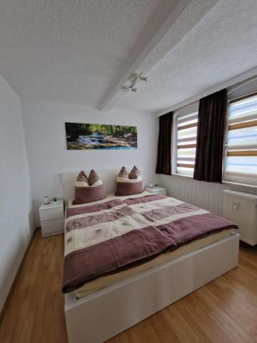 ein Schlafzimmer mit einem großen Bett mit zwei Kissen darauf in der Unterkunft Ferienwohnung Haus Sonnenblick in Burkhardtsdorf