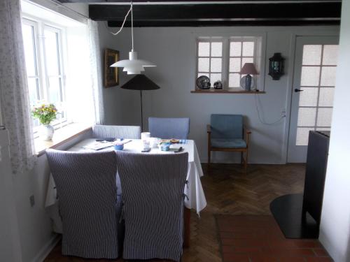 ein Esszimmer mit einem weißen Tisch und Stühlen in der Unterkunft Paradiset Holiday House in Blans