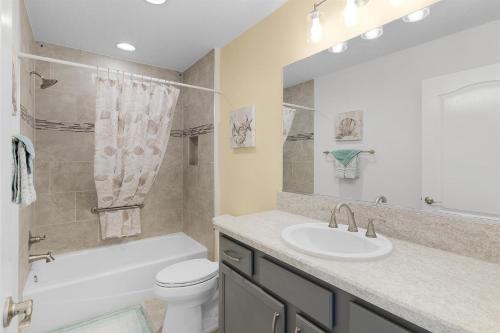 a bathroom with a sink and a tub and a toilet at Relaxing, Golf, Pools, Hiking, events in Wildwood