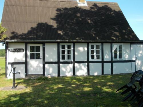 ein weißes und schwarzes Haus mit schwarzem Dach in der Unterkunft Paradiset Holiday House in Blans