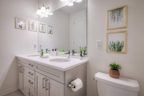 a bathroom with a sink and a toilet and a mirror at Modern Comforts and Spacious Living 4B/3.5 Bath in Pickering