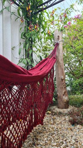 a hammock tied to a tree stump in a garden at Quarto Jaraguá/São Luís in Jaraguá do Sul