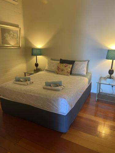 1 dormitorio con 1 cama con 2 toallas en Charming Queeenslander in City Centre en Cairns