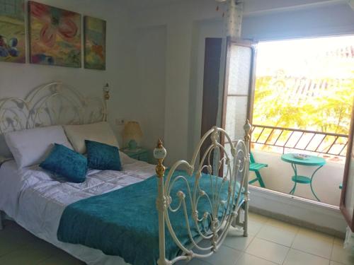 1 dormitorio con 1 cama, ventana y balcón en La Jacaranda, en Casarabonela
