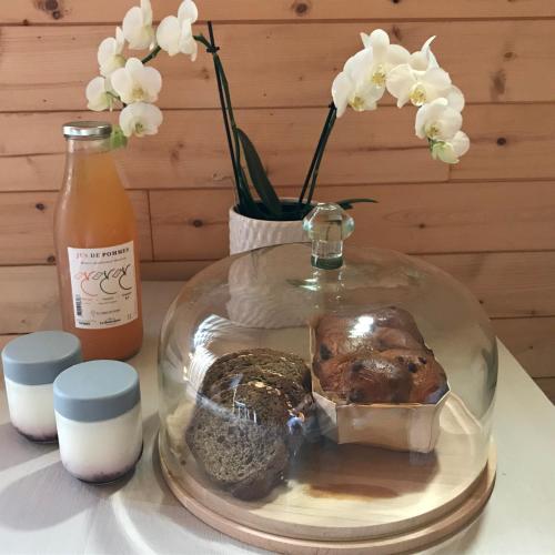 une plaque de verre avec de la nourriture sur une table avec des fleurs dans l'établissement Cabane ZEN OCEAN, les cabanes océanes Montalivet, à Vendays-Montalivet