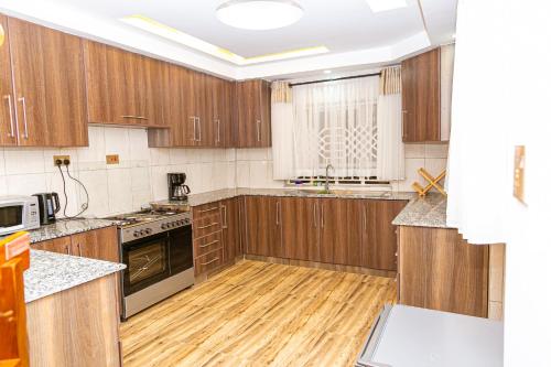 a kitchen with wooden cabinets and a wooden floor at MacCinray Villa Kisii in Kisii