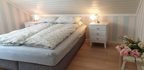 1 dormitorio con 1 cama con 2 mesitas de noche y 2 lámparas en Slåta - The Dragon-valley cabin, en Lyngdal