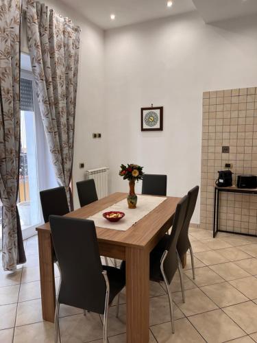 a dining room with a wooden table and chairs at Santa Maria Home in Naples