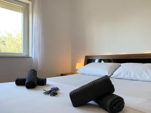 a bedroom with two beds with towels and a window at LARUS apartment in Kastel Luksic