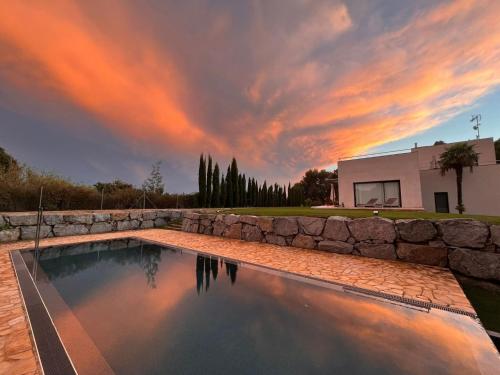 una piscina con una pared de piedra junto a una casa en Belvilla by OYO Villa Sant Andreu de Llavaneres, en Sant Andreu de Llavaneres