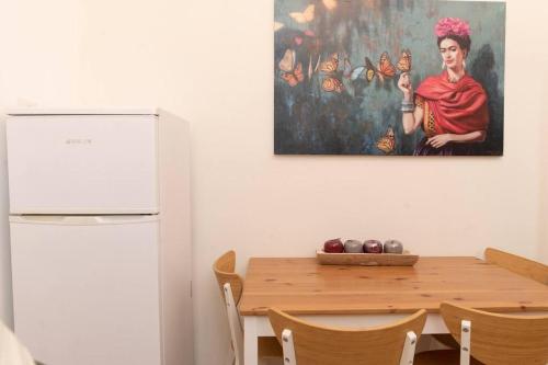 海法的住宿－Bride House haifa，厨房配有桌子,墙上挂有绘画作品