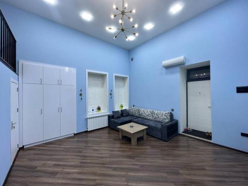 a living room with a couch and a blue wall at Turquoise Apartment in Baku