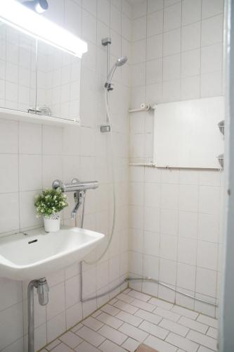 ein weißes Badezimmer mit einem Waschbecken und einem Spiegel in der Unterkunft Oulu city center 4-room apartment Parking in Oulu