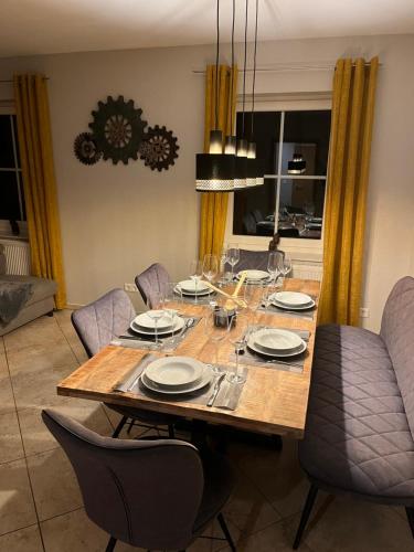 comedor con mesa de madera y sillas en Ferienwohnung Körber, en Gössweinstein