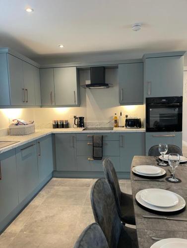 a kitchen with blue cabinets and a table and chairs at Harbour view apartment in Annalong