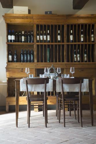 a dining room with a table and chairs and wine bottles at Tenuta Sant'Ilario in Gambassi Terme
