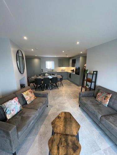a living room with two couches and a table at Harbour view apartment in Annalong