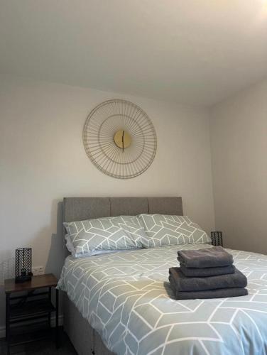 a bedroom with a bed with a clock on the wall at Harbour view apartment in Annalong