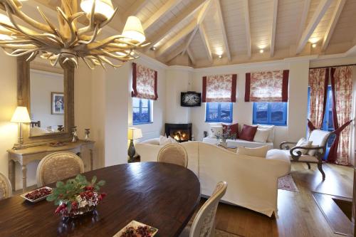a dining room and living room with a table and chairs at Zagori Suites Luxury Residences in Vitsa