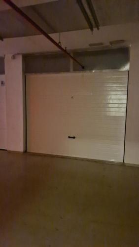 an empty room with a white garage door with a window at Zadar Sunset Penthouse with spectacular view and jacuzzi in Zadar