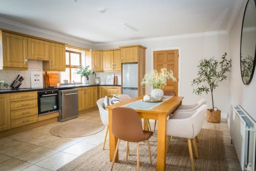 eine Küche mit einem hölzernen Esstisch und Stühlen in der Unterkunft Cosy family home in Strandhill in Sligo