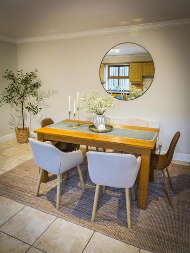 a dining room table with chairs and a mirror at Cosy family home in Strandhill in Sligo