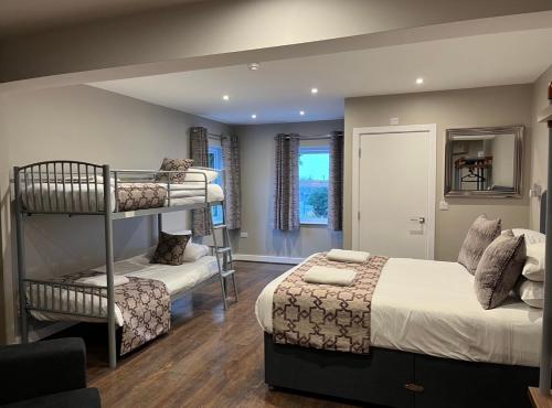 a bedroom with two beds and a bunk bed at The Vine Hotel Chapel st Leonards in Skegness