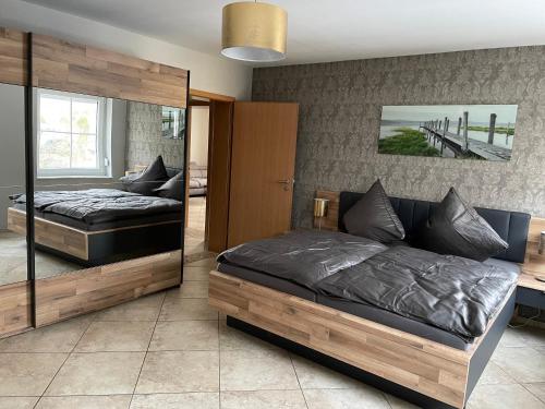1 dormitorio con 2 camas y espejo en Ferienwohnung Körber en Gößweinstein