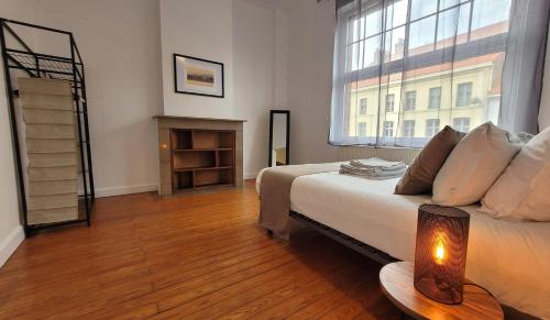 una camera con un letto e una grande finestra di Le Lumia a Saint-Omer