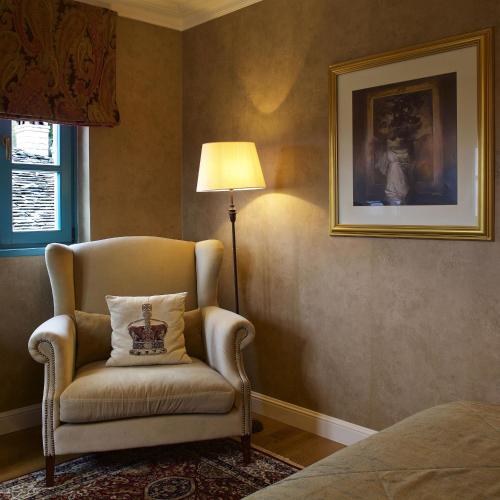 a chair with a pillow in a room with a lamp at Zagori Suites Luxury Residences in Vitsa
