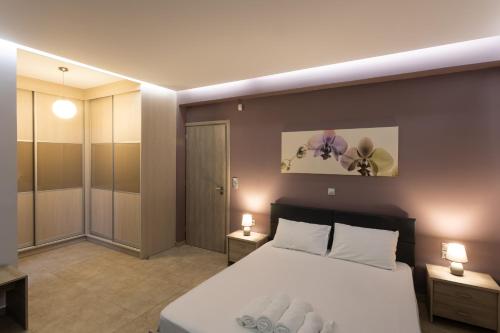 Saronic TopView Villa في غالاتاس: غرفة نوم بسرير كبير ومصباحين