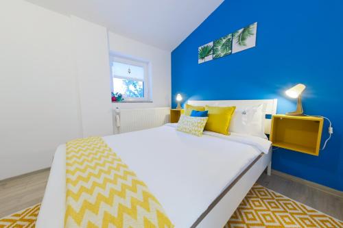 una camera da letto blu e bianca con un letto con pareti gialle e blu di Casa AVA a Straja