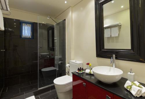 a bathroom with a sink and a toilet and a shower at Zagori Suites Luxury Residences in Vitsa